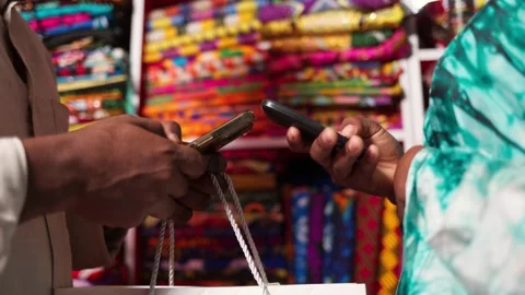 African male customer making mobile money payment using smartphone in a shop Video stock 345330826