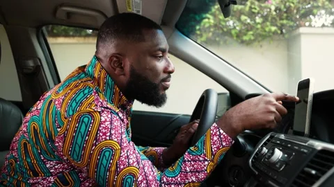 African male driver using his smartphone for GPS maps and navigation  Stock Footage 346732412