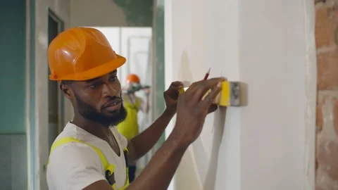 African male worker checking level of the wall with the bubble level tool Stock Footage 142215757