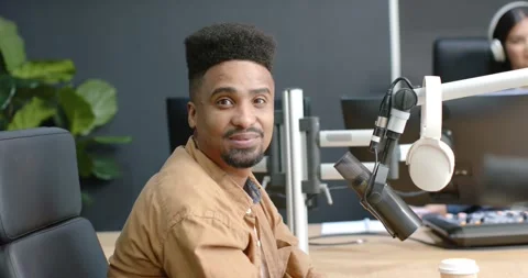 African man adjusting headset and positioning mic on boom while preparing to Stock Footage 344964326