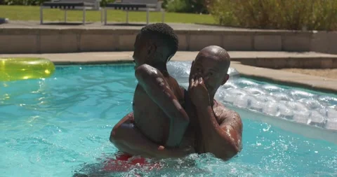 African man and boy playing, man lifting boy while supporting arms at backyard Stock Footage 341468567