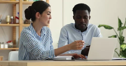 African man apprentice ask Indian woman experienced colleague for help 스톡 동영상 191800103