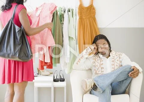 African man bored while woman shops Stock Photos