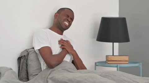 African Man with Chest Pain while Sitting in Bed Video stock 287905032