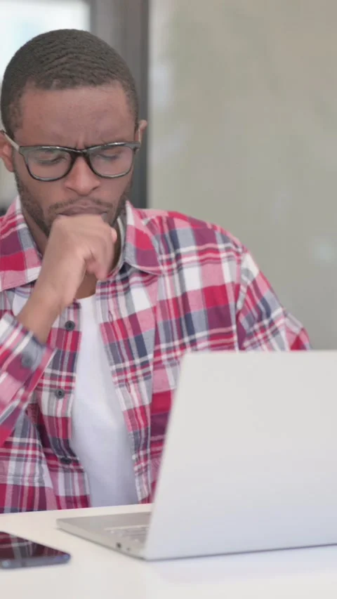 African Man Coughing while using Laptop, Vertical Video Stock Footage 340040083