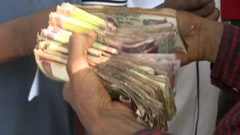 An African man counts a large bundle of paper money. Close-up of money in hands. Vídeo Stock 170066796