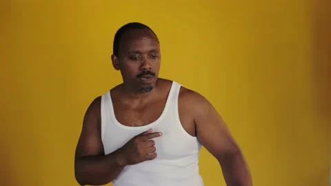 African man dancing against a yellow background.Black man in a white T-shirt Stock Footage 201291894