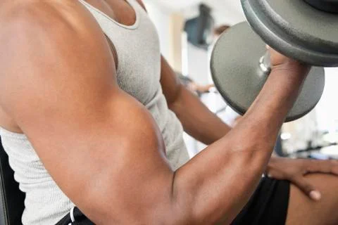 African man doing biceps curls with dumbbell Stock Photos