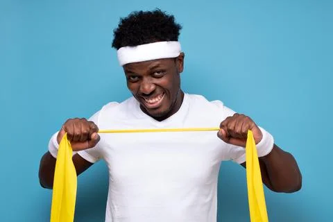 African man doing exercise on his hands with elastic fitness tape. Stock Photos