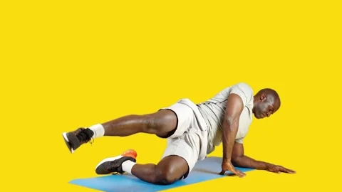 African man doing exercises lifting the leg on a mat Stock Footage 241184536