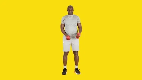 African man doing lateral alternate shoulder raising exercises with dumbbells Stock Footage 243554319