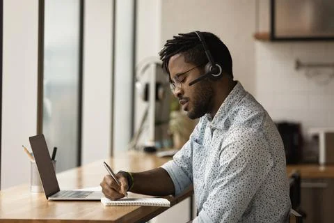African man e-learns language using video call app and laptop Fotos Stock