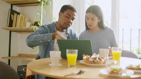 African man explaining something to her partner using a laptop Stock Footage 236424004