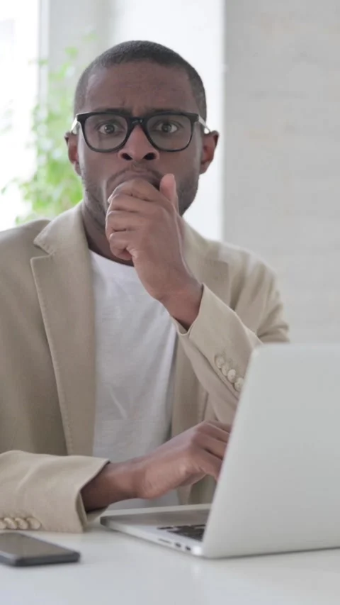 African Man Feeling Shocked while using Laptop in Office, Vertical Video Stock Footage 337350037