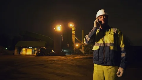 African man geologist or mining engineer talking on smartphone late at night in Stock Footage 124303894