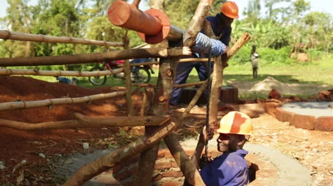 An African man going into a hole to build a water well in rural Uganda Stock Footage 58477690