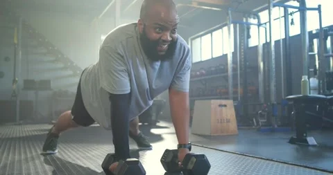 African man gray-tee shorts wide-plank-on-mat, pushing up and rowing Stock Footage 339321050