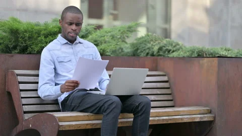African Man having Loss working on Papers and Laptop 스톡 동영상 136033495