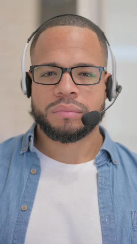 African Man with Headset Looking at Camera in Call Center, vertical video Stock Footage 325700679