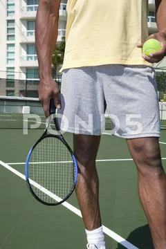 African man holding tennis ball and racket Stock Photos