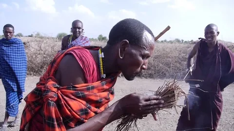 African Man Inflates The Fire In A Tribe. Stock Footage