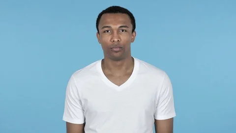 African Man Looking at Camera Isolated on Blue Background Stock Footage 99014562