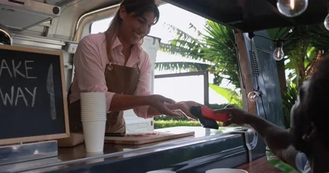 African man making contactless payment with mobile phone at food truck Stock Footage 156454058