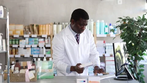 African man pharmacist uses computer at workplace Stock Footage 327129540