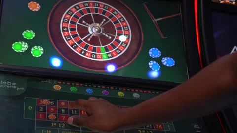 African man playing a game of roulette on a slot machine 스톡 동영상 256794087