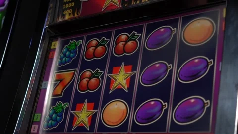 African man playing slot machine at a mid-sized casino Stock Footage 256790380