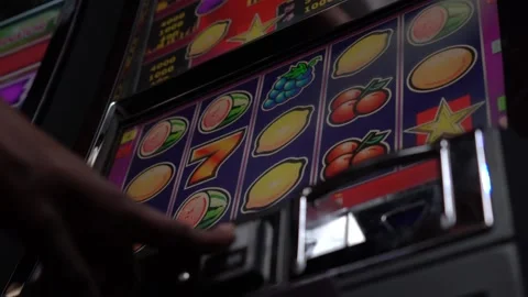 African man playing slot machine games at a casino Stock Footage 256791489