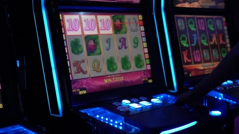 African man playing slot machine games at a casino Stock Footage 256792105
