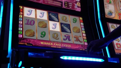 African man playing slot machine games at a casino 스톡 동영상 256792684