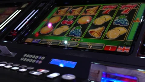 African man playing slot machine games at a casino Stock Footage 256793600