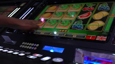 African man playing slot machine games at a casino Stock Footage 256793637