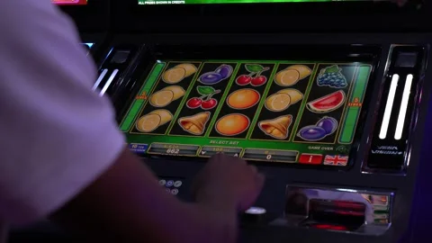 African man playing slot machine games at a casino Stock Footage 256793725