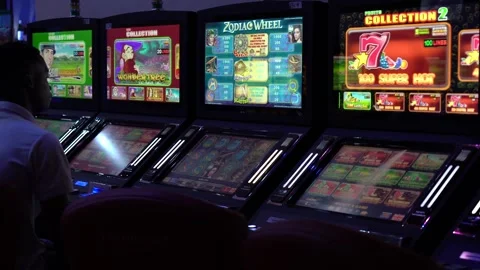 African man playing slot machine games at a casino Stock-Footage 256795301