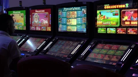 African man playing slot machine games at a casino Stock Footage 256795534