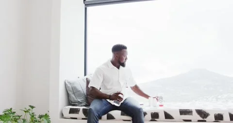 African man pouring after positioning glass, wiping bottle with cloth on window Stock Footage 344851753