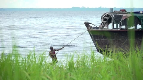 African man pulling a boat with a rope Video stock 158803839
