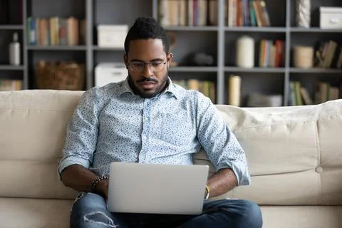 African man put notebook on lap do remote work Stock Photos