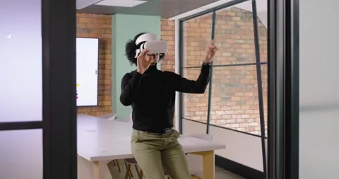 African man putting on white VR headset adjusting while interacting with virtual Stock Footage 339958690