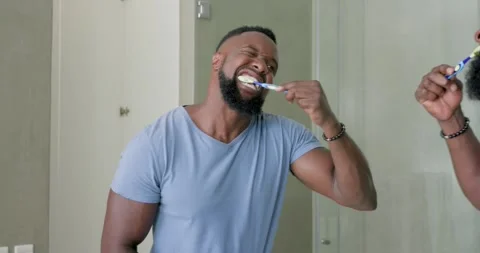 African man reaching for toothbrush, brushing teeth, rinsing and wiping face at Stock Footage 335748469