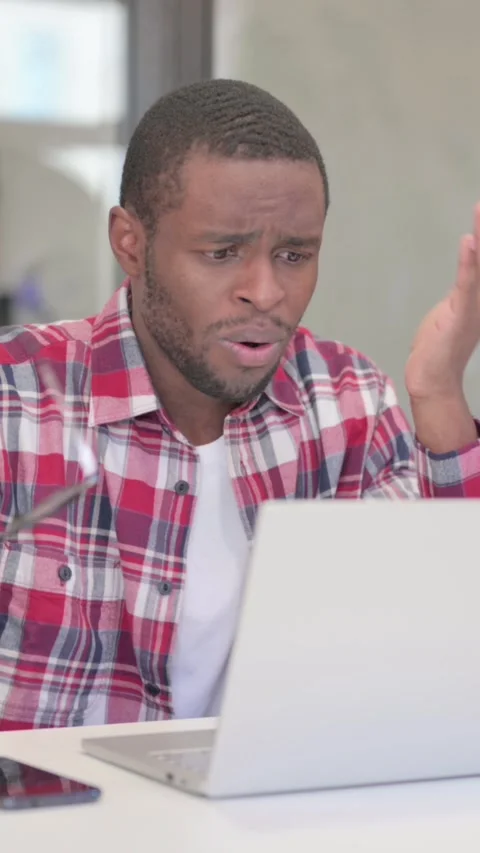 African Man Reacting to Loss While using Laptop, Vertical Video Stock Footage 340040153