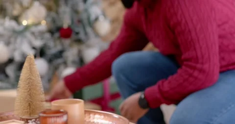 African man Santa hat reaching from right, inspecting gold gift on copper-tray Stock Footage 342084802