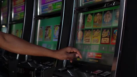 African man selecting a slot machine game at a casino Stock Footage 256790657