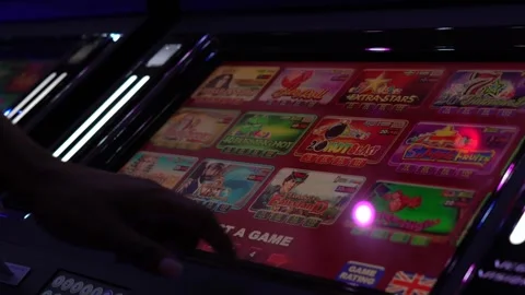 African man selecting a slot machine game at a casino Stock Footage 256793310