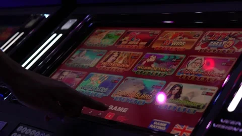 African man selecting a slot machine game at a casino Vídeos de archivo 256793375