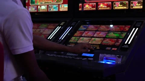 African man selecting a slot machine game at a casino Stock Footage 256793490