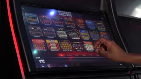 African man selecting a slot machine game at a casino Stock Footage 256793726